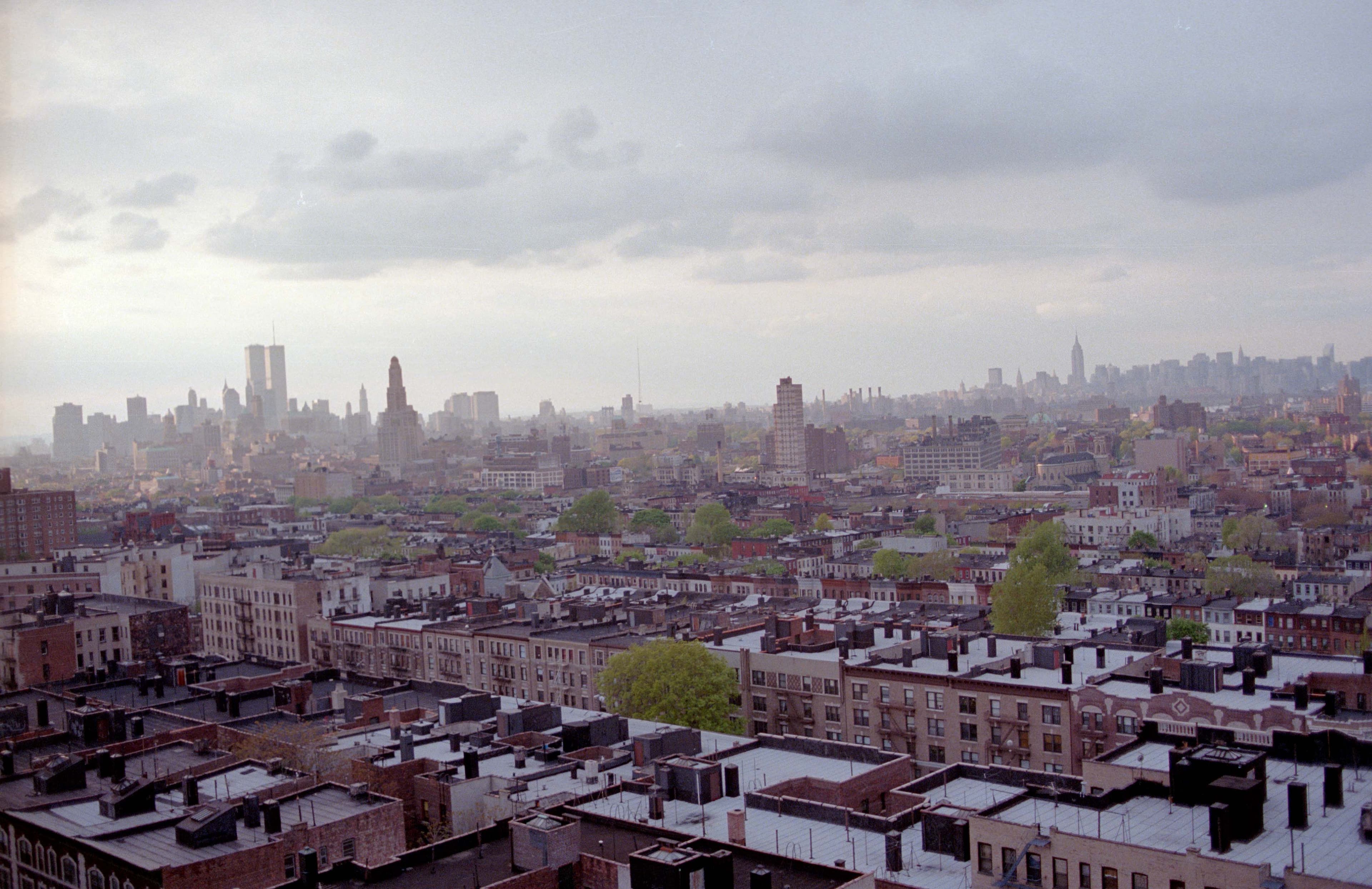 A city skyline seen beneath a broad cloudy sky