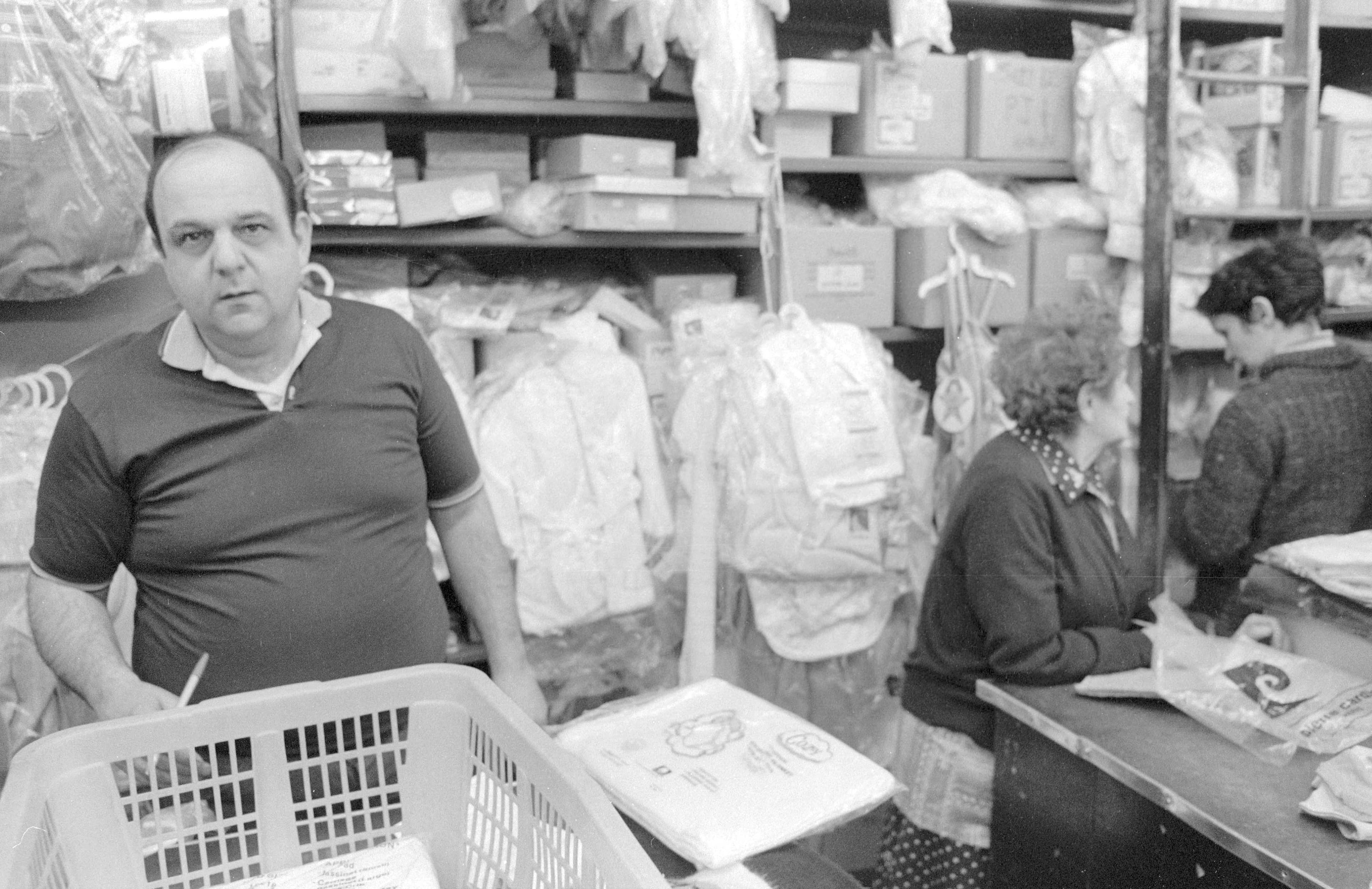 A man carries a laundry basket inside a neighborhood shop